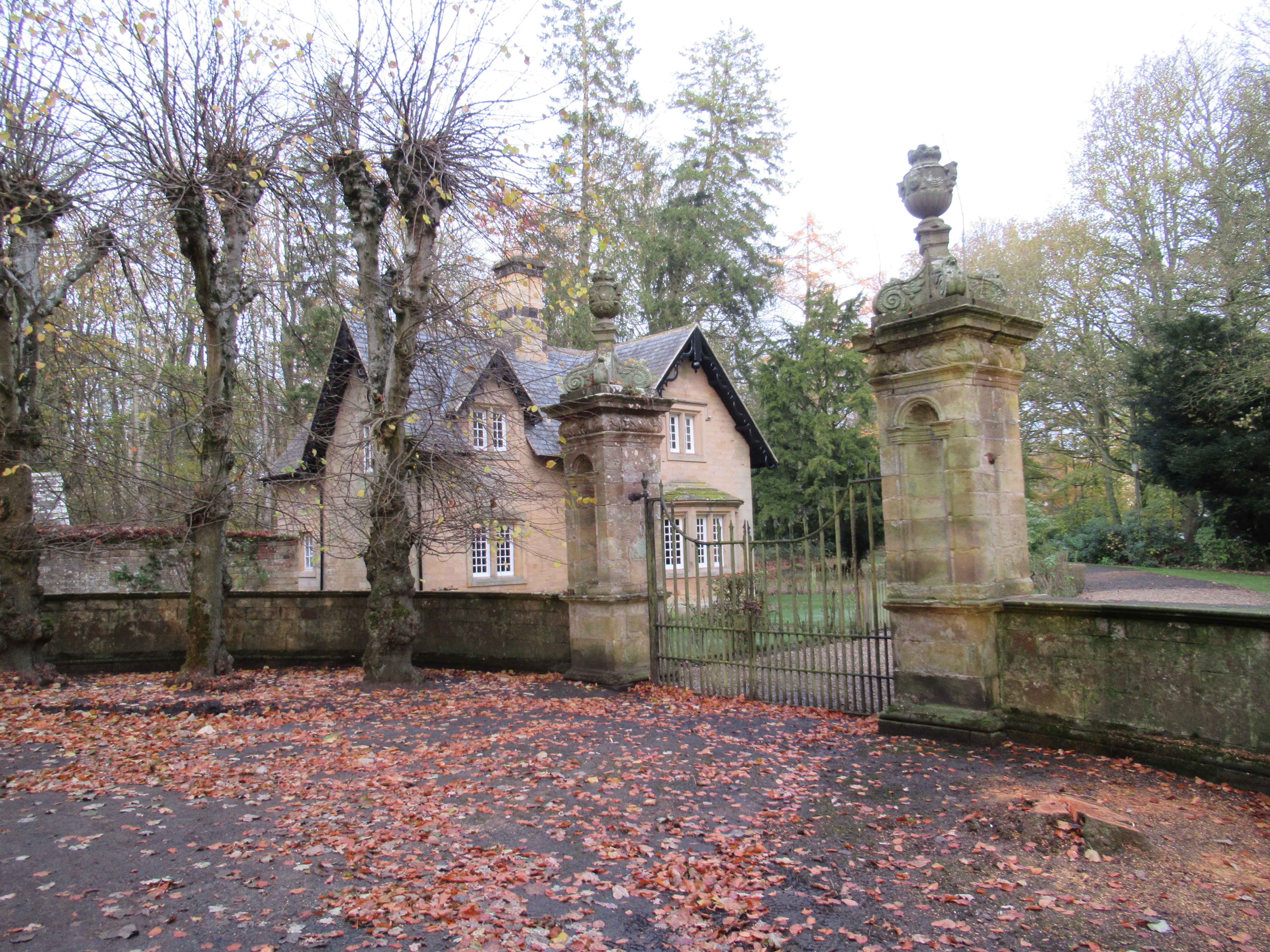 West Lodge and stone entrance gates to the Matfen Hall estate in autumn
